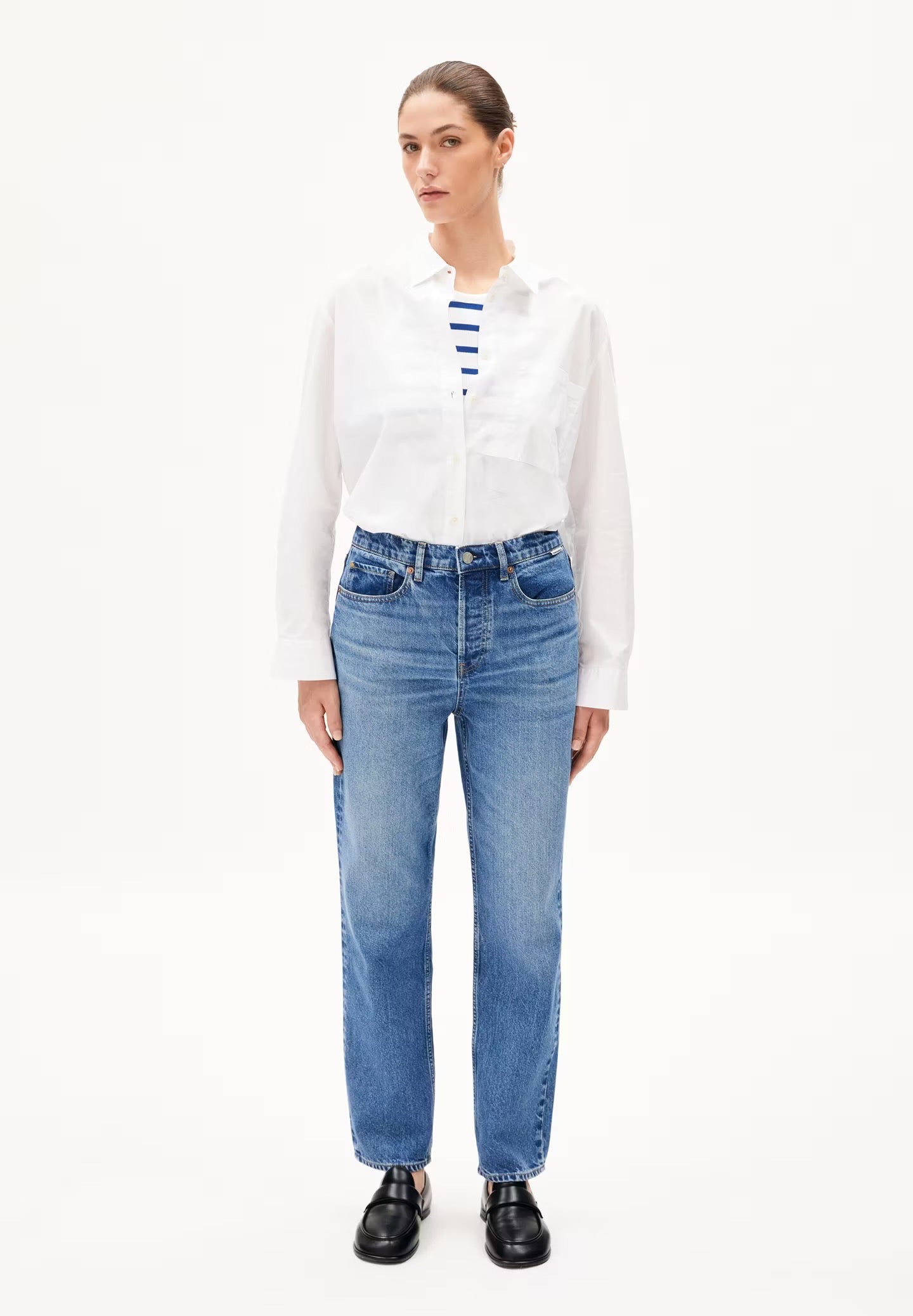 High waisted straight leg jeans from Armedangels. Five pockets, button placket, regular length. Made from 100% recycled cotton. Slightly washed out mid blue.