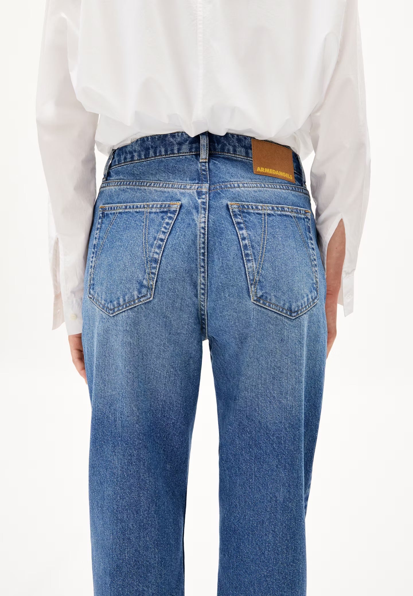 High waisted straight leg jeans from Armedangels. Five pockets, button placket, regular length. Made from 100% recycled cotton. Slightly washed out mid blue.