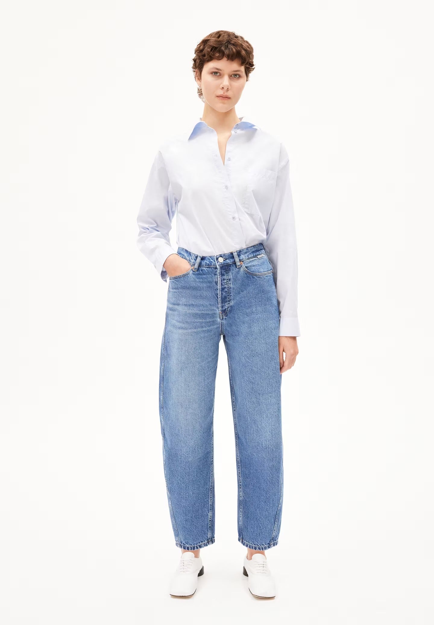 Baarly barrel leg jeans from Armedangels. Ankle length and a high waist. Button closure. Side and back pockets. Mid denim blue. Made from sustainable recycled cotton.