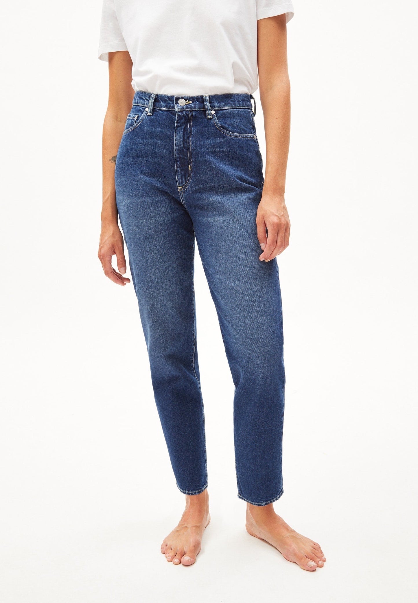 Mom fit jeans in mid blue from Armedangels. High waist, tapered, slightly cropped leg, zip closure, side pockets and back pockets. Made from sustainable organic cotton.