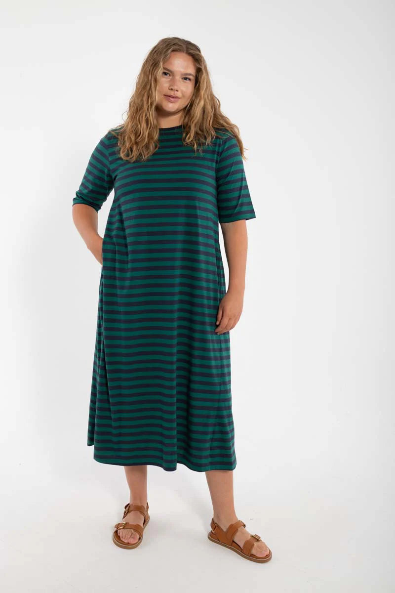 Model wearing midi length t-shirt dress by Danefae, made from 100% organic cotton. Round neckline and elbow length sleeves. Horizontal stripes in navy blue and dark green.