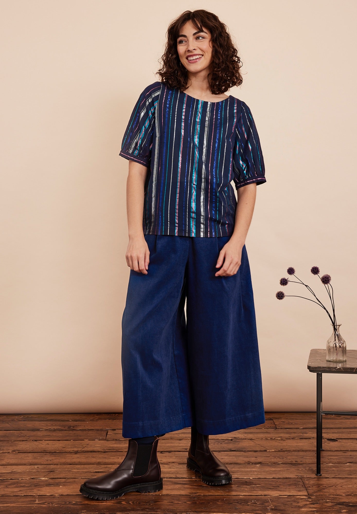 Festive top from Emily and Fin. Vertical lurex stripes of various with in blue, fuchsia and gold on a navy background. Boatneck, 1/2 sleeves. Made from cotton.