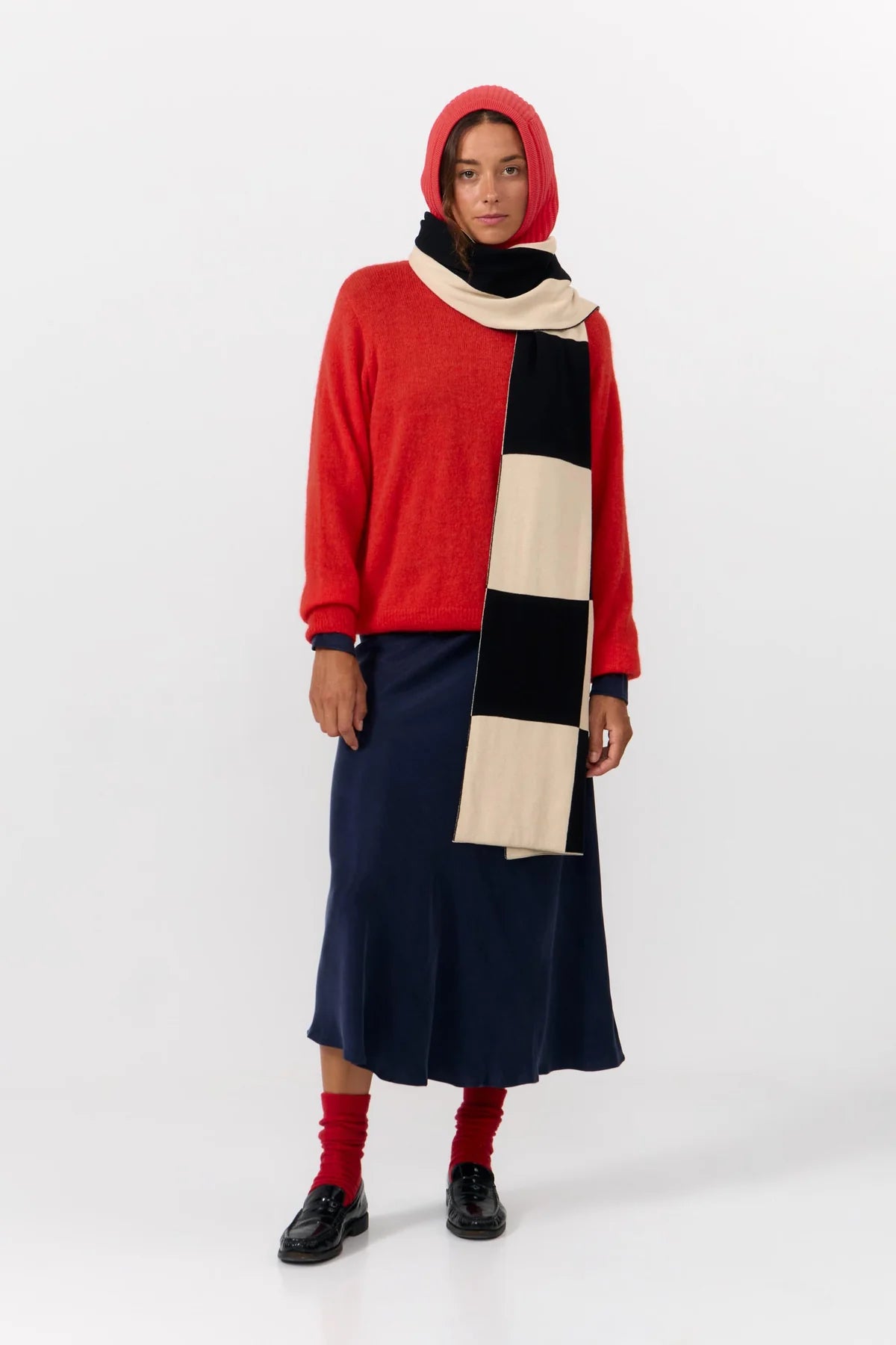 Oversized scarf from Suite13Lab. Rectangular shape, approximately 205 cm long and 42 cm wide. Jacquard knit in a large check board pattern in off white and black on one side and wide vertical stripes in the same colours on the other. Made in India from 100% organic cotton.