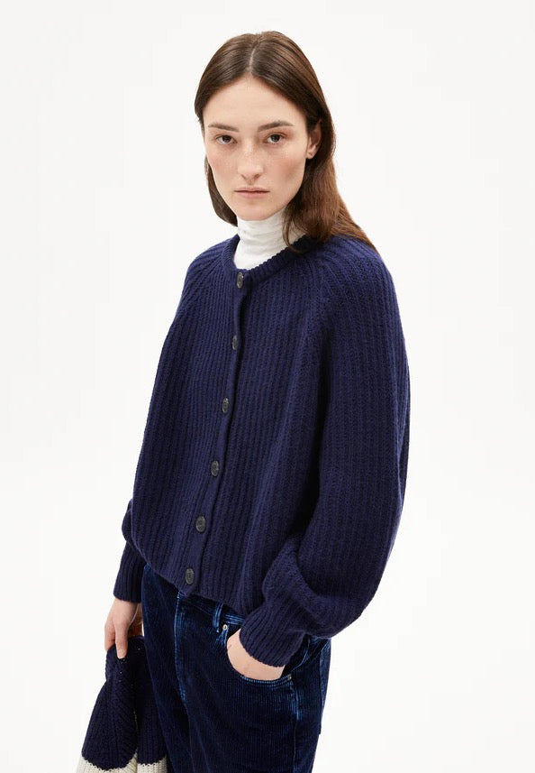 SELMAA cardigan from ARMEDANGELS, featuring a chunky knit with a ribbed texture and a relaxed, generous fit. Made from a soft blend of organic wool and organic wool. Button placket closure at the front. Regular length, slightly boxy fit, round neck and slightly bell-shaped long sleeves.