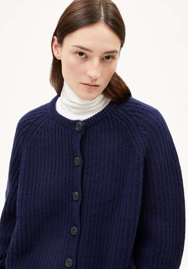 SELMAA cardigan from ARMEDANGELS, featuring a chunky knit with a ribbed texture and a relaxed, generous fit. Made from a soft blend of organic wool and organic wool. Button placket closure at the front. Regular length, slightly boxy fit, round neck and slightly bell-shaped long sleeves.