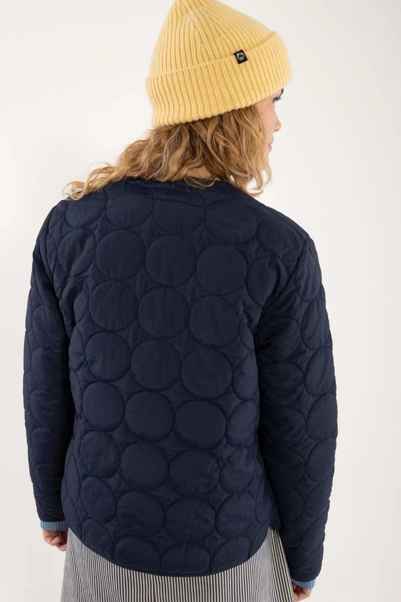 Daneland quilted jacket from Danefae Copenhagen in classic navy. Perfect as a thermo layer underneath a coat or worn by itself as a transitional jacket. Round neck, long sleeves and button closure with four buttons in the same colour as the jacket. Roomy side pockets. Round hem. Made from 100% nylon. Water repellent in light showers.