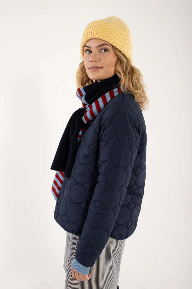 Daneland quilted jacket from Danefae Copenhagen in classic navy. Perfect as a thermo layer underneath a coat or worn by itself as a transitional jacket. Round neck, long sleeves and button closure with four buttons in the same colour as the jacket. Roomy side pockets. Round hem. Made from 100% nylon. Water repellent in light showers.