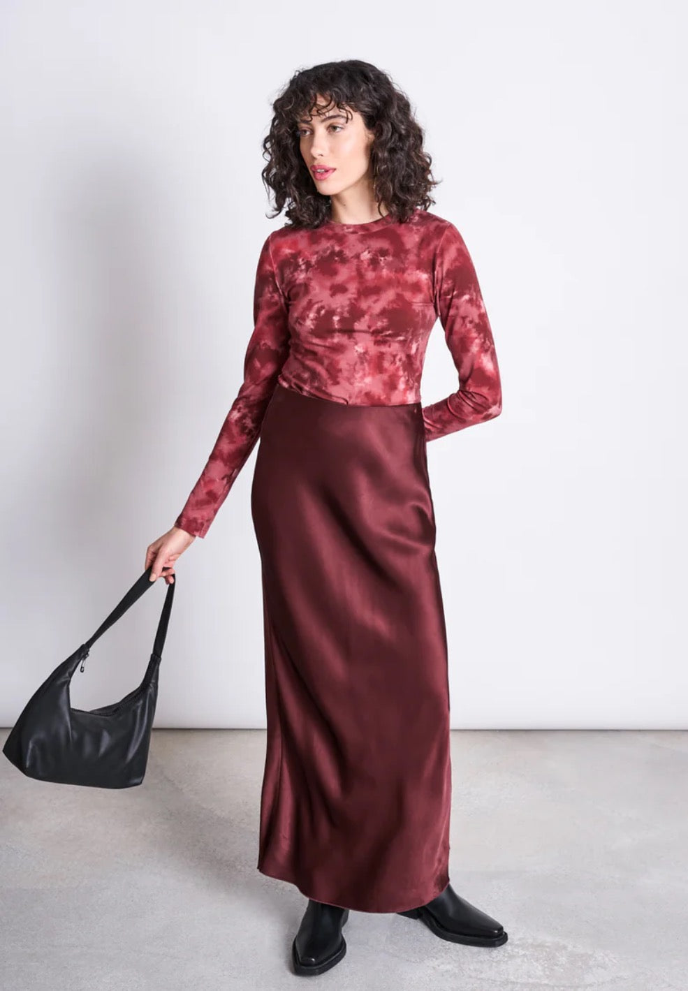 Elegant maxi slip skirt front Jan n June, in a darker shade of rust red. Made from sustainable viscose, with a shiny silk-like finish. Straight cut, slightly flared towards the hem. Elastic waistband.
