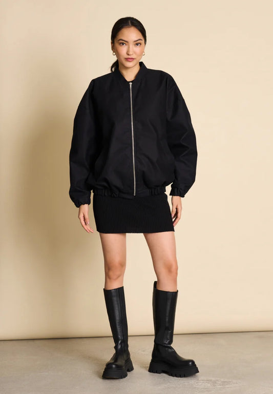 Bomber jacket by Jan n June. Oversized unisex fit. Long sleeves, bomber collar and zipper closure. Lined. Made from sustainable organic cotton. In black.