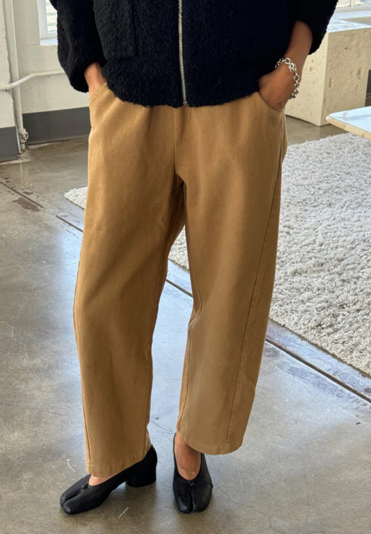 Arc Pants by Le Bon Shoppe. Barrel leg trousers made from cotton canvas, with deep side pockets and an elastic waistband. The colour is tobacco.