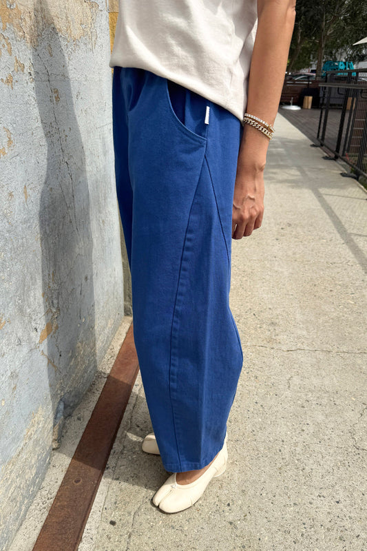 Person wearing azure blue Arc pants from Le Bon Shoppe and a white shirt standing on a sidewalk.
