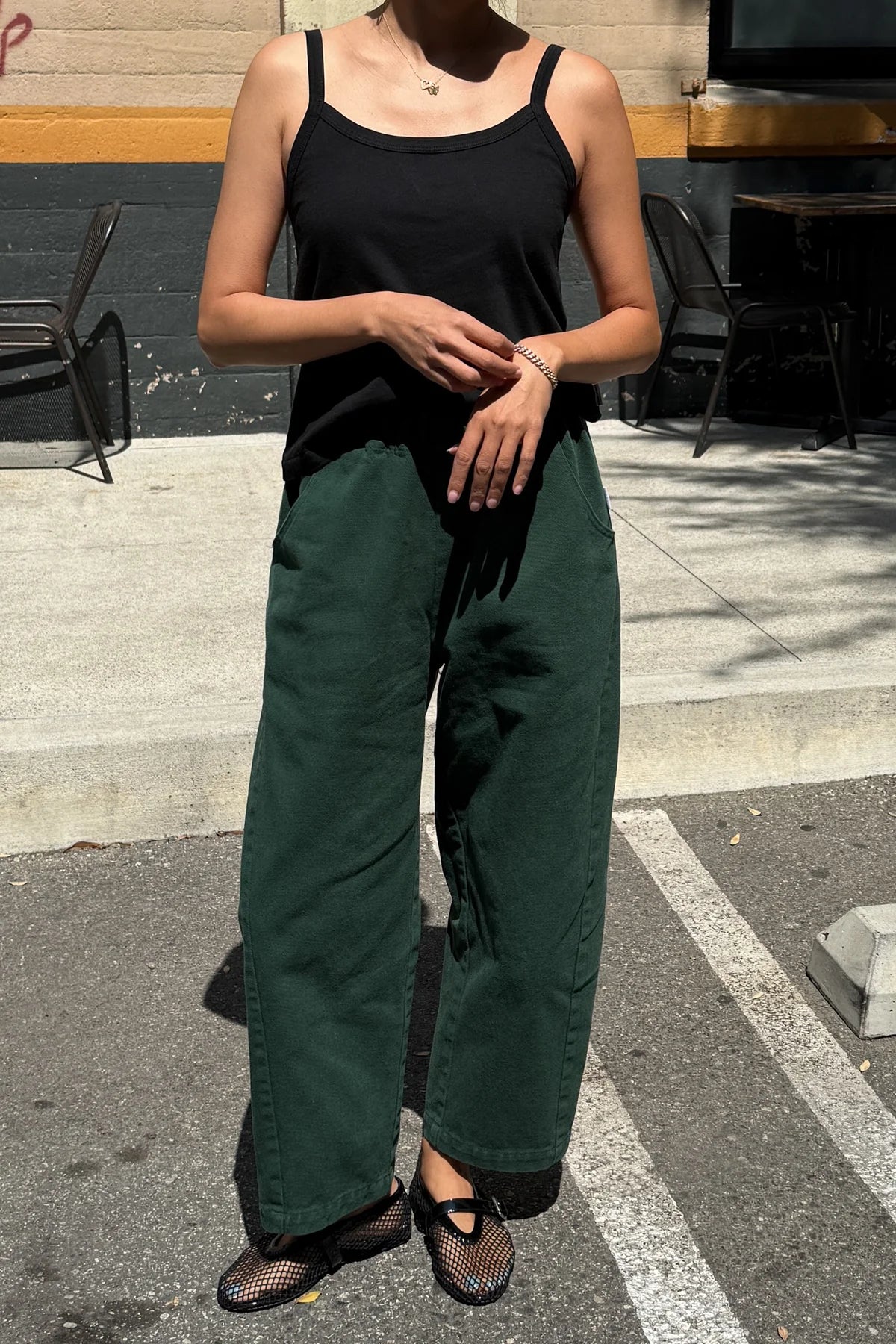 Arc Pants from Le Bon Shoppe. Barrel leg trousers made from durable cotton canvas. Featuring an elastic high waist, deep side pockets, and a slightly curved, cropped leg with a unique side panel. In a deep pine green colour.