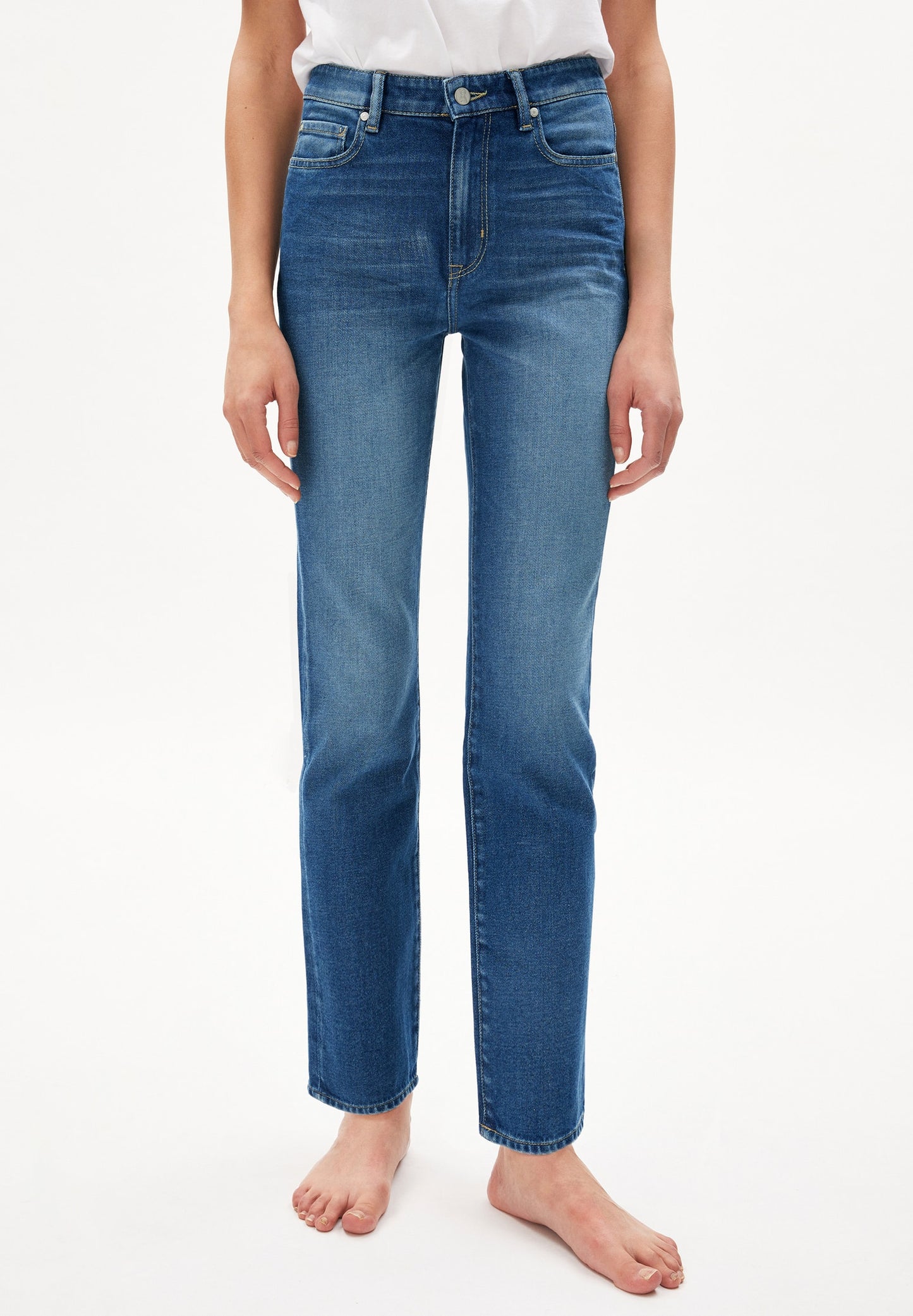 Straight leg mid waist jeans from Armedangels. Made from sustainable organic cotton with a little bit of stretch for extra comfort. Full length. Zipper closure, side and back pockets. In a mid blue shade of denim.
