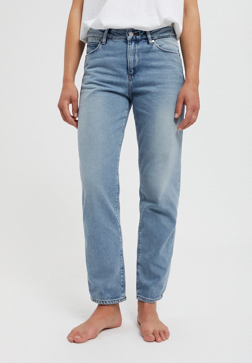 Straight leg mid waist jeans from Armedangels, slightly cropped length. Made from organic cotton. With zipper closure, side pockets and back pockets. In mid denim blue.