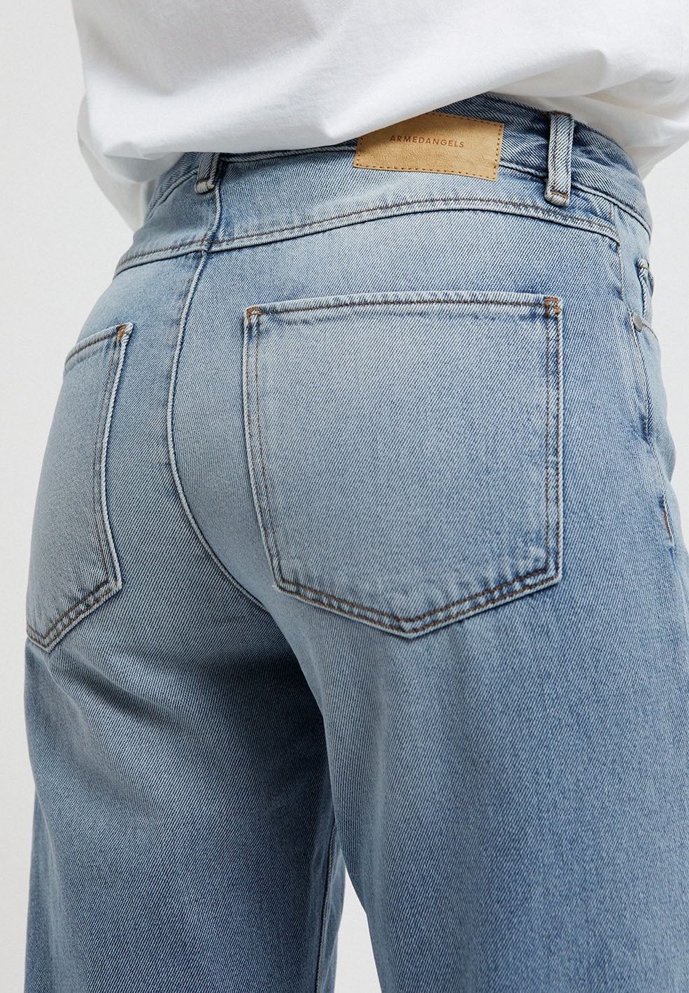 Straight leg mid waist jeans from Armedangels, slightly cropped length. Made from organic cotton. With zipper closure, side pockets and back pockets. In mid denim blue.