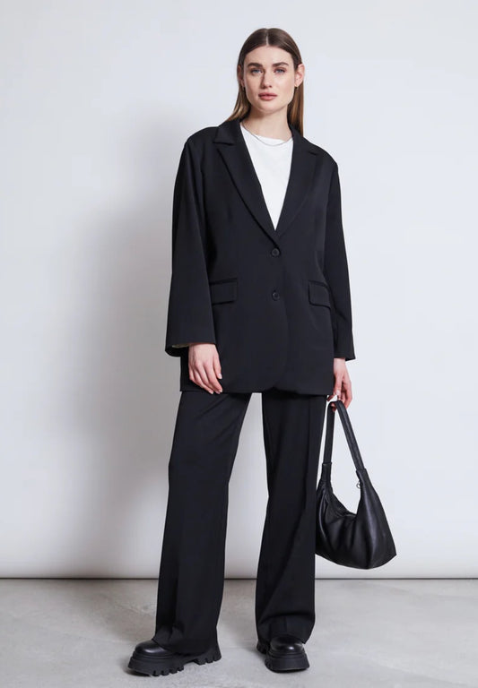 Black suit jacket by Jan n June. Oversized fit. Button closure, front pockets. Made from sustainable recycled polyester.