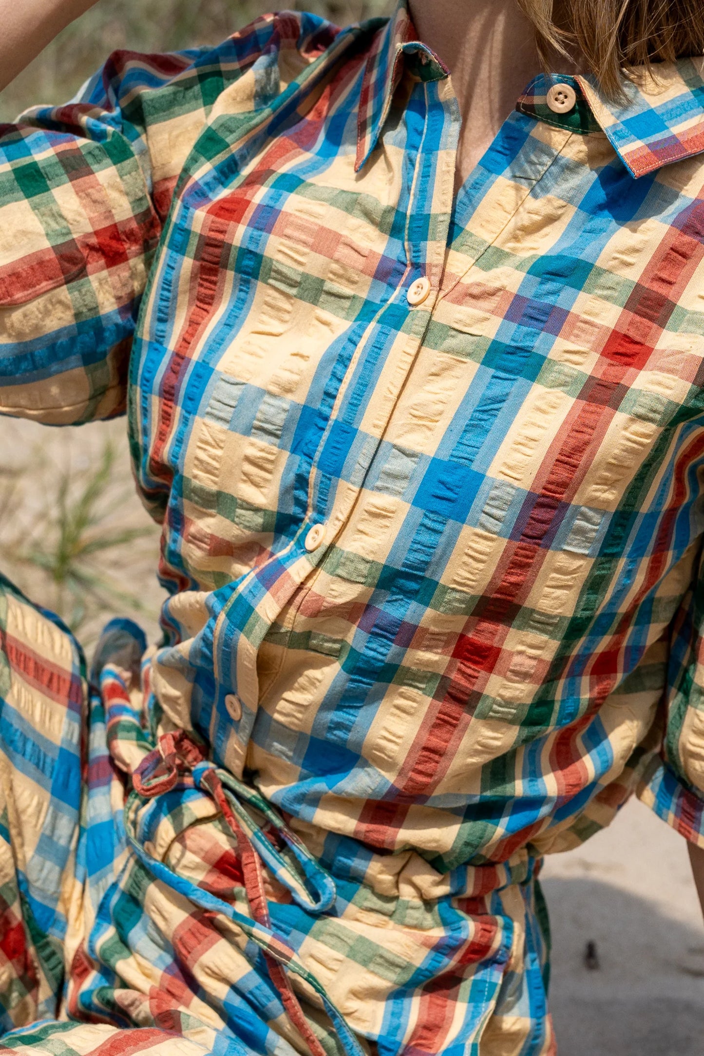 Close-up of a colourful jumpsuit shirt with a blurred natural background
