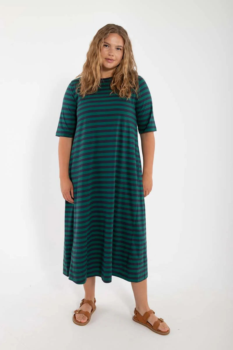 Model wearing midi length t-shirt dress by Danefae, made from 100% organic cotton. Round neckline and elbow length sleeves. Horizontal stripes in navy blue and dark green.