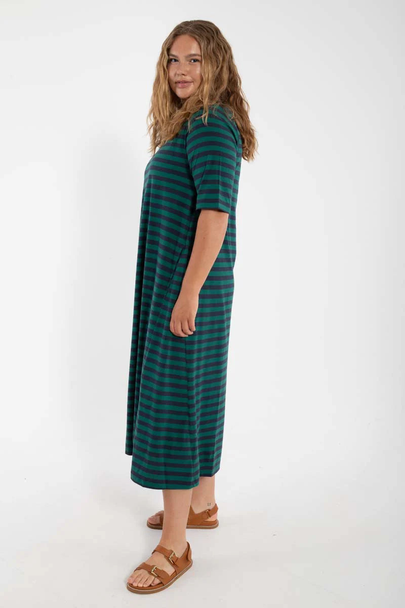 Model wearing midi length t-shirt dress by Danefae, made from 100% organic cotton. Round neckline and elbow length sleeves. Horizontal stripes in navy blue and dark green.