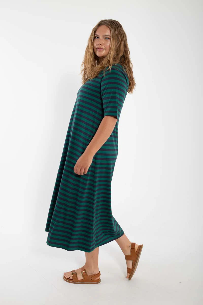 Model wearing midi length t-shirt dress by Danefae, made from 100% organic cotton. Round neckline and elbow length sleeves. Horizontal stripes in navy blue and dark green.