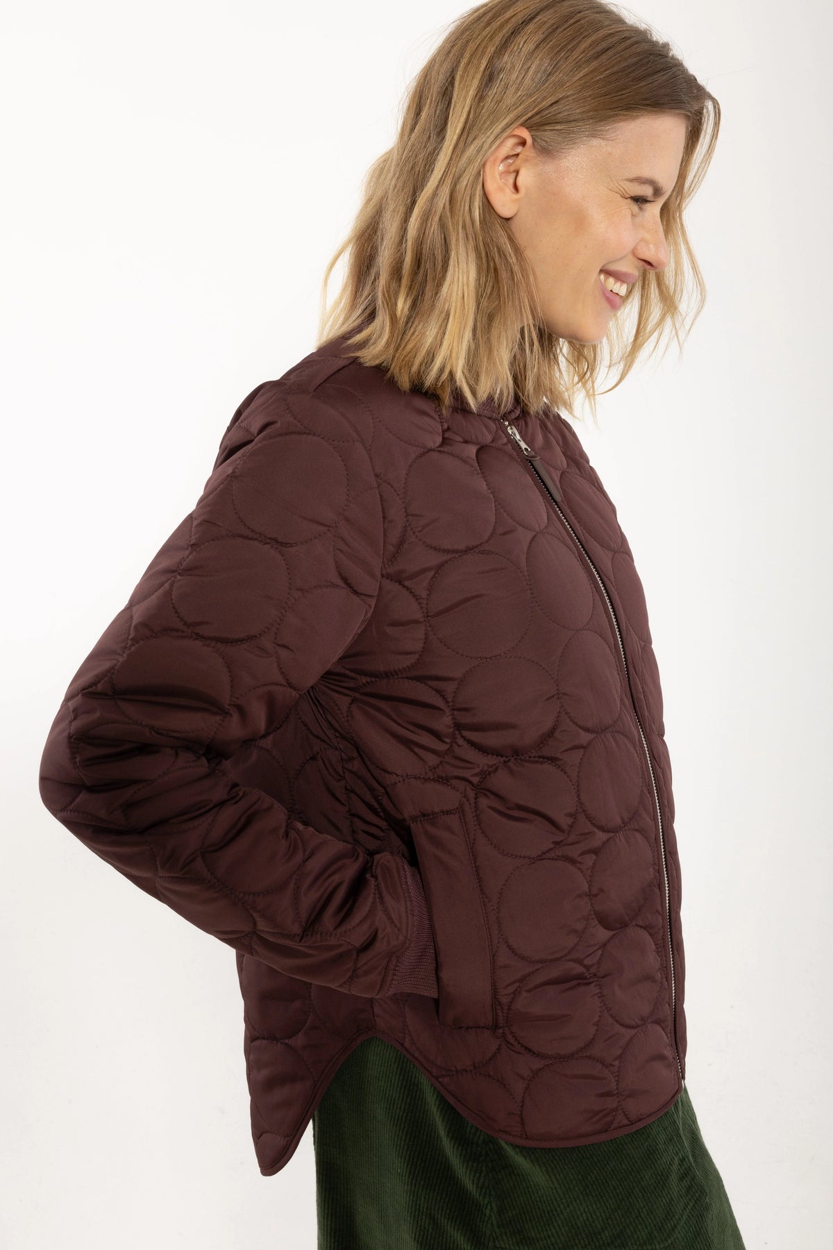 Woman wearing a dark red quilted jacket from Danefae.