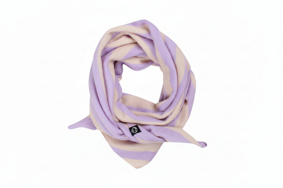 A soft knit scarf by Danefae with alternating horizontal stripes of light lavender purple and cream, styled in a loop on a solid white background. A small black square logo tag is attached near the bottom.
