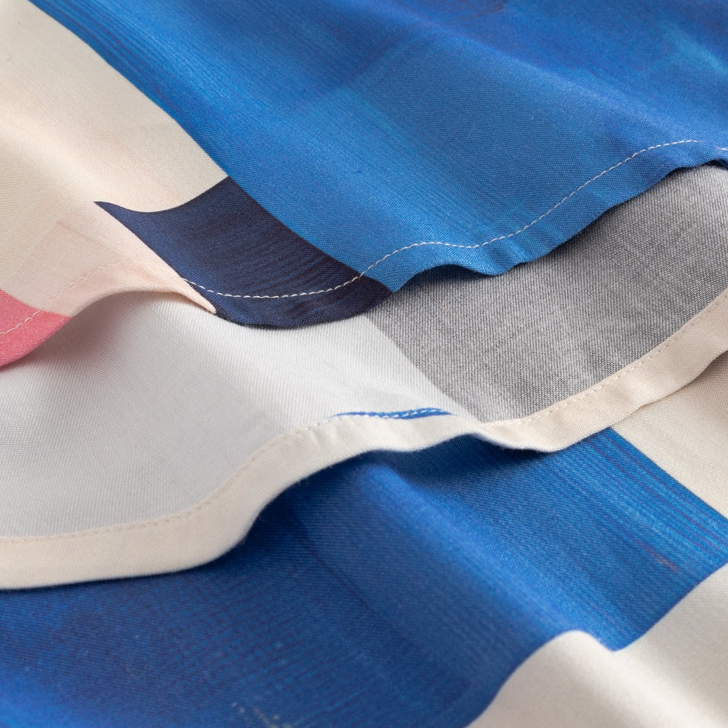 Close-up of fabric with blue, gray, and pink colors.