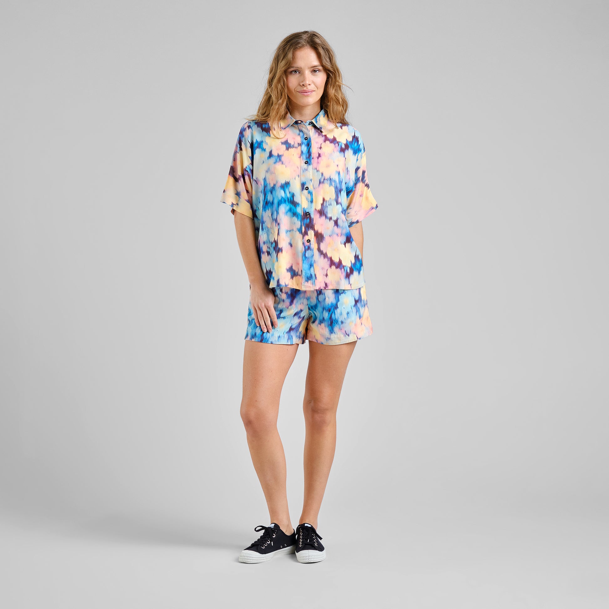 Woman wearing a colorful outfit on a gray background