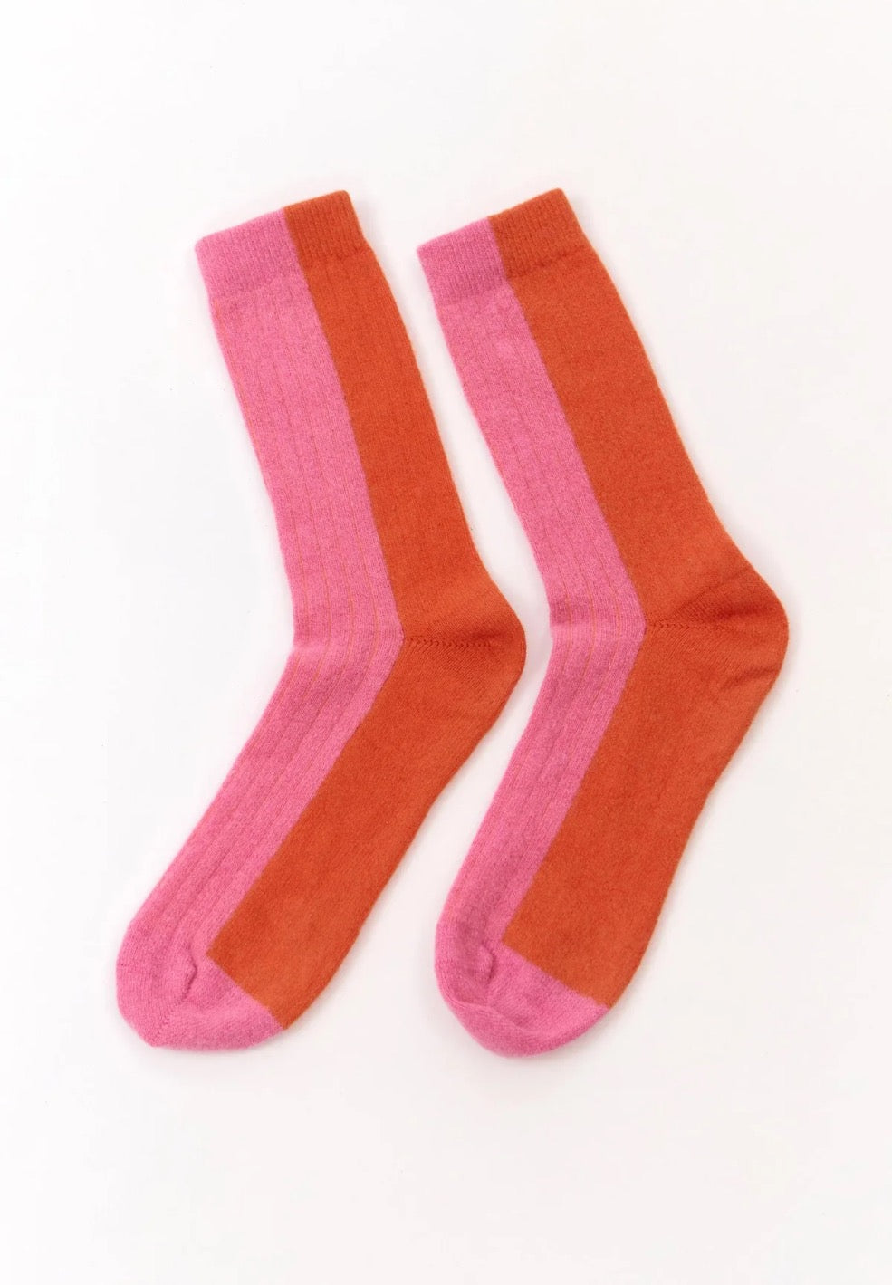 Colourful wool blend socks from the Spanish brand Suite13Lab. Made from 70% merino wool, 27% polyamide, 3% elastomer. With a pink front and top side of the foot and an orange back and heel. Made in Spain.