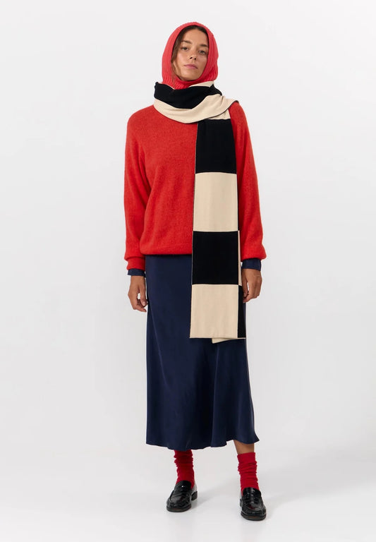 Oversized scarf from Suite13Lab. Rectangular shape, approximately 205 cm long and 42 cm wide. Jacquard knit in a large check board pattern in off white and black on one side and wide vertical stripes in the same colours on the other. Made in India from 100% organic cotton.