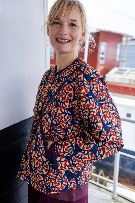 Woman wearing a patterned quilted jacket by Danefae with a blurred background