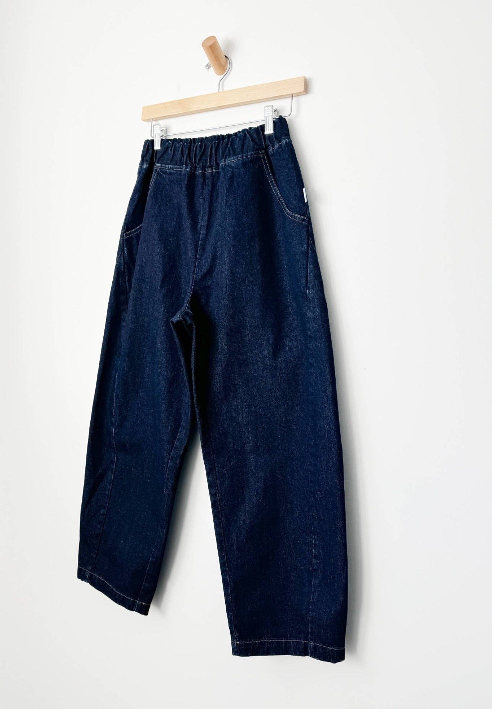 Arc Pants from Le Bon Shoppe. Barrel leg jeans with an elastic high waist and a slightly curved, cropped leg. Made from pure cotton, in a dark blue denim colour. With side pockets.