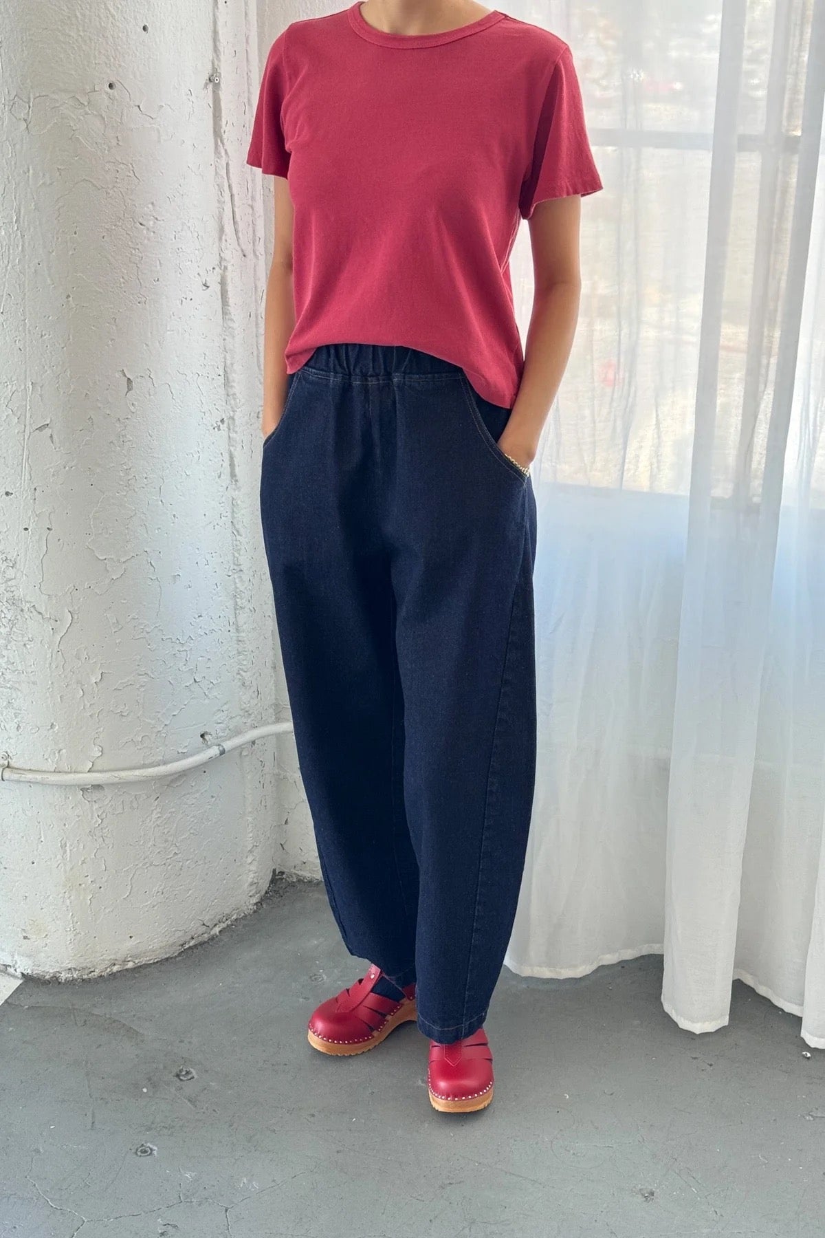 Arc Pants from Le Bon Shoppe. Barrel leg jeans with an elastic high waist and a slightly curved, cropped leg. Made from pure cotton, in a dark blue denim colour. With side pockets.