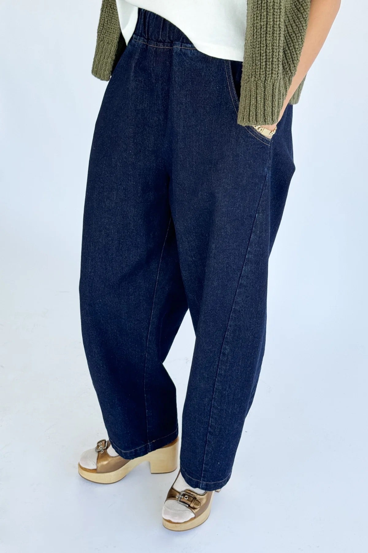 Arc Pants from Le Bon Shoppe. Barrel leg jeans with an elastic high waist and a slightly curved, cropped leg. Made from pure cotton, in a dark blue denim colour. With side pockets.