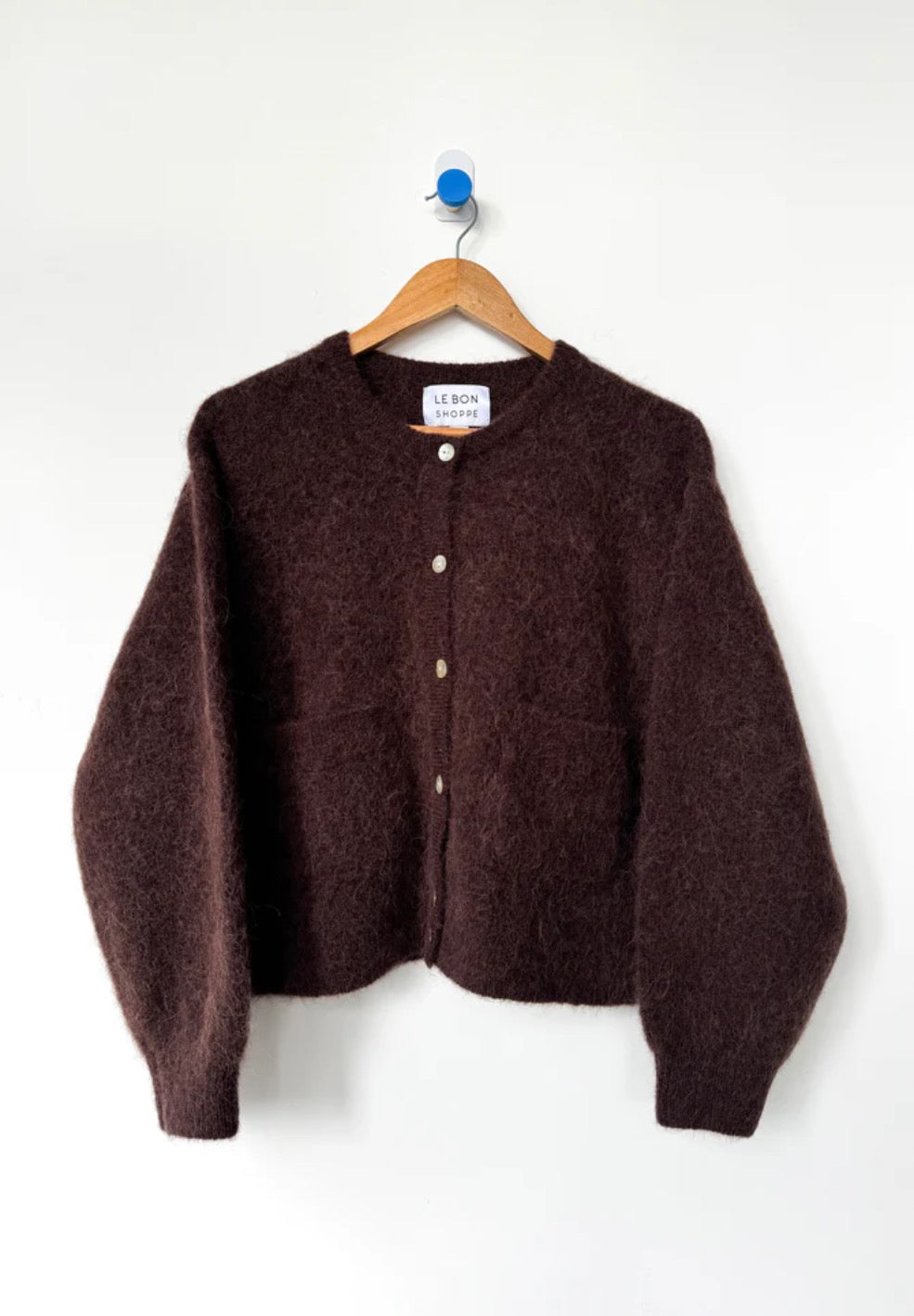 Chocolate Brown Amelie cardigan from Le Bon Shoppe on a hanger against a white background