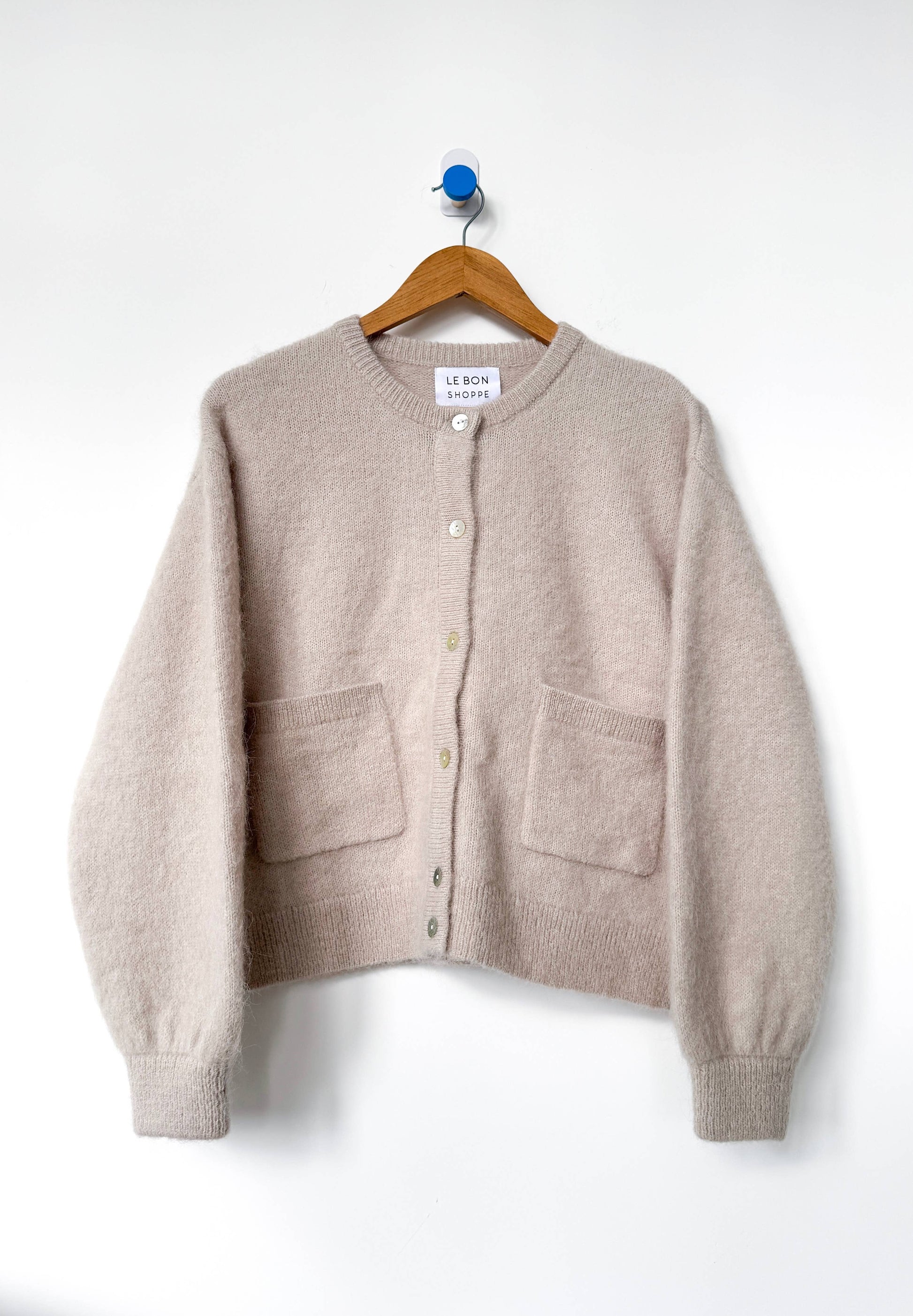 Beige Amelie cardigan from Le Bon Shoppe  on a hanger against a white background