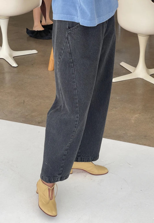 Arc Pants from Le Bon Shoppe. Barrel leg trousers made from durable cotton canvas. Featuring an elastic high waist, deep side pockets, and a slightly curved, cropped leg with a unique side panel. Washed out black denim.