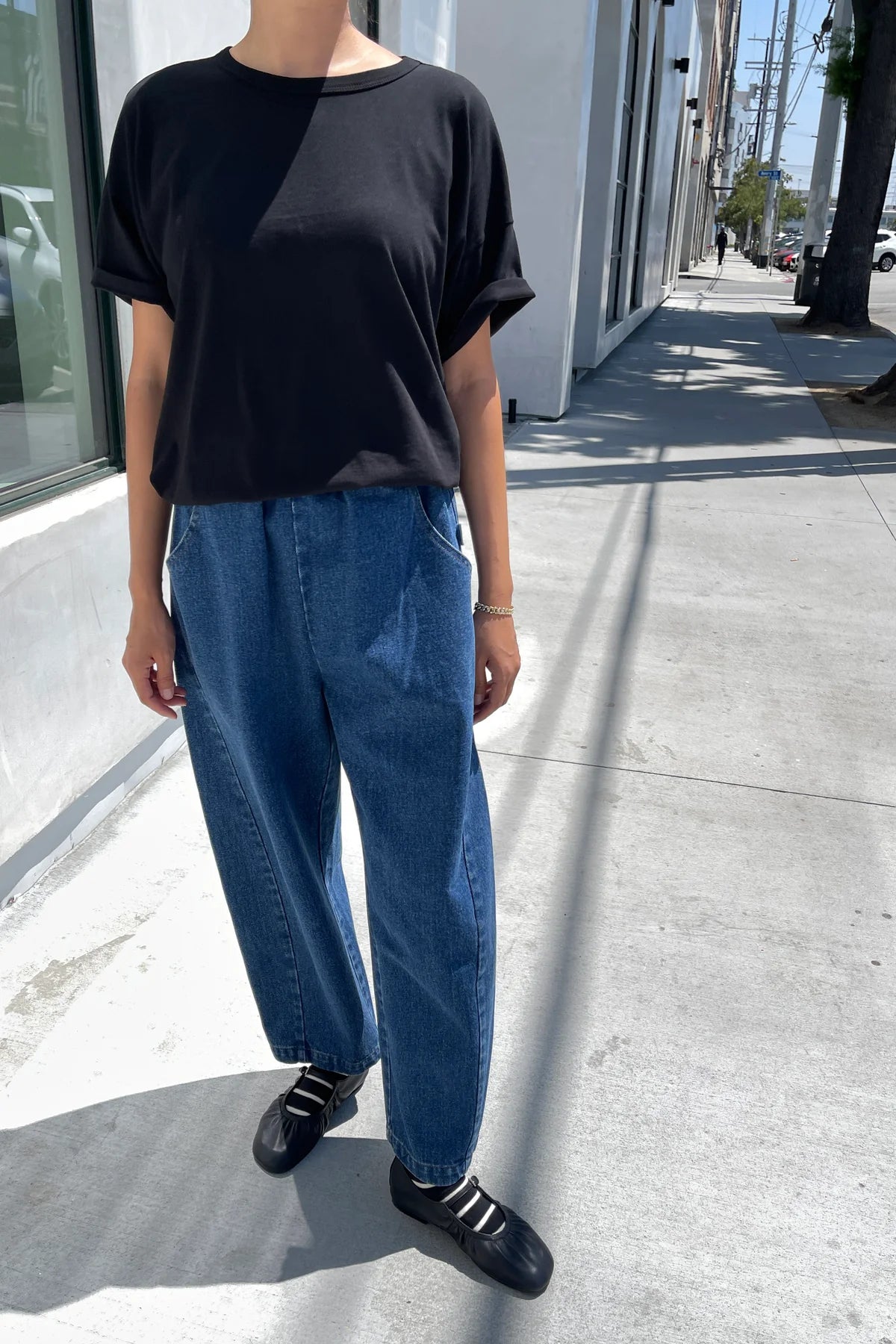 Arc Pants from Le Bon Shoppe. Barrel leg jeans made from durable 100% cotton denim. Featuring an elastic high waist, deep side pockets, and a slightly curved, cropped leg with a unique side panel. In a mid denim blue colour.