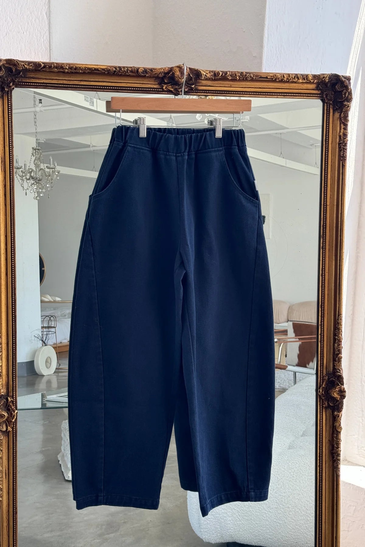 Arc Pants from Le Bon Shoppe. Barrel leg trousers made from durable cotton canvas. Featuring an elastic high waist, deep side pockets, and a slightly curved, cropped leg with a unique side panel. In a dark navy colour.