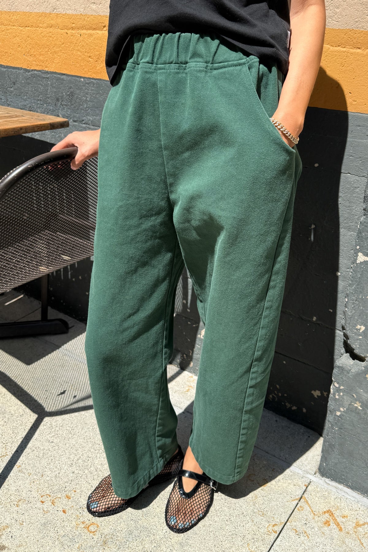 Arc Pants from Le Bon Shoppe. Barrel leg trousers made from durable cotton canvas. Featuring an elastic high waist, deep side pockets, and a slightly curved, cropped leg with a unique side panel. In a deep pine green colour.