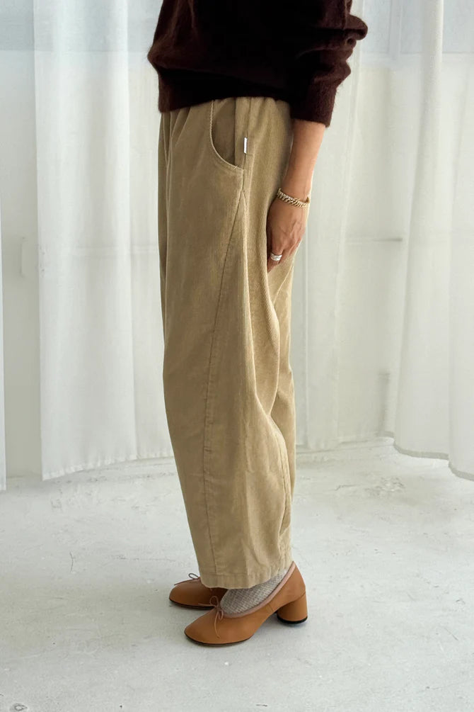 Woman wearing khaki beige corduroy Arc pants from Le Bon Shoppe and brown shoes in a minimalistic setting