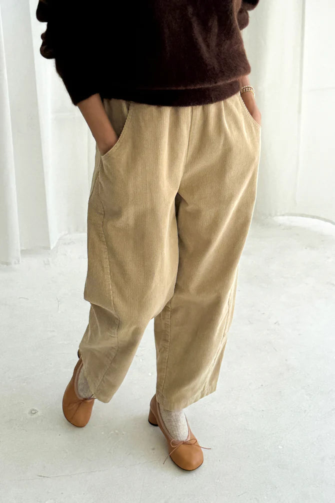 Woman wearing khaki beige wide-leg corduroy Arc pants from Le Bon Shoppe and brown shoes on a white background