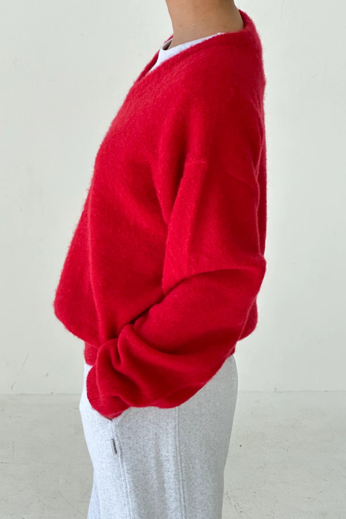 Red James mohair jumper from Le Bon Shoppe worn by a woman on a plain background