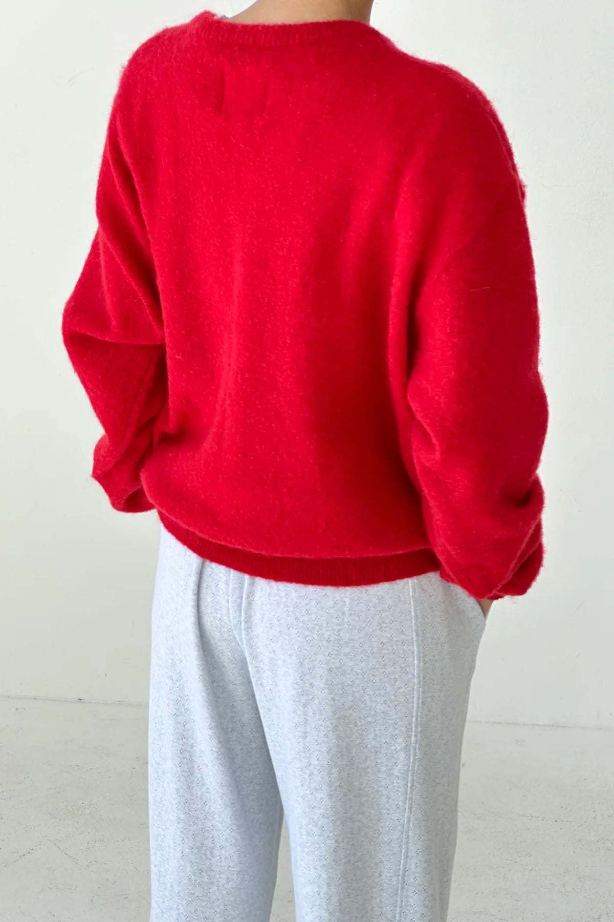 Woman wearing the red James mohair jumper from Le Bon Shoppe 
 and light gray pants on a white background