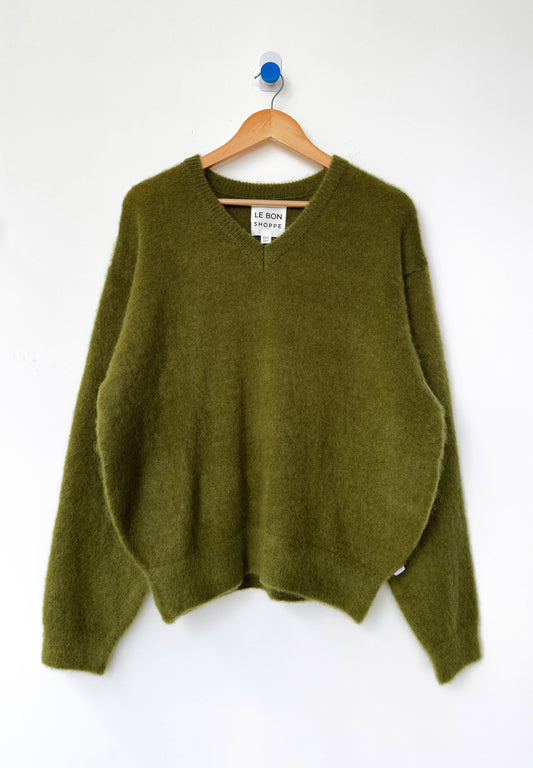 Leaf green mohair James sweater from Le Bon Shoppe on a wooden hanger against a white background