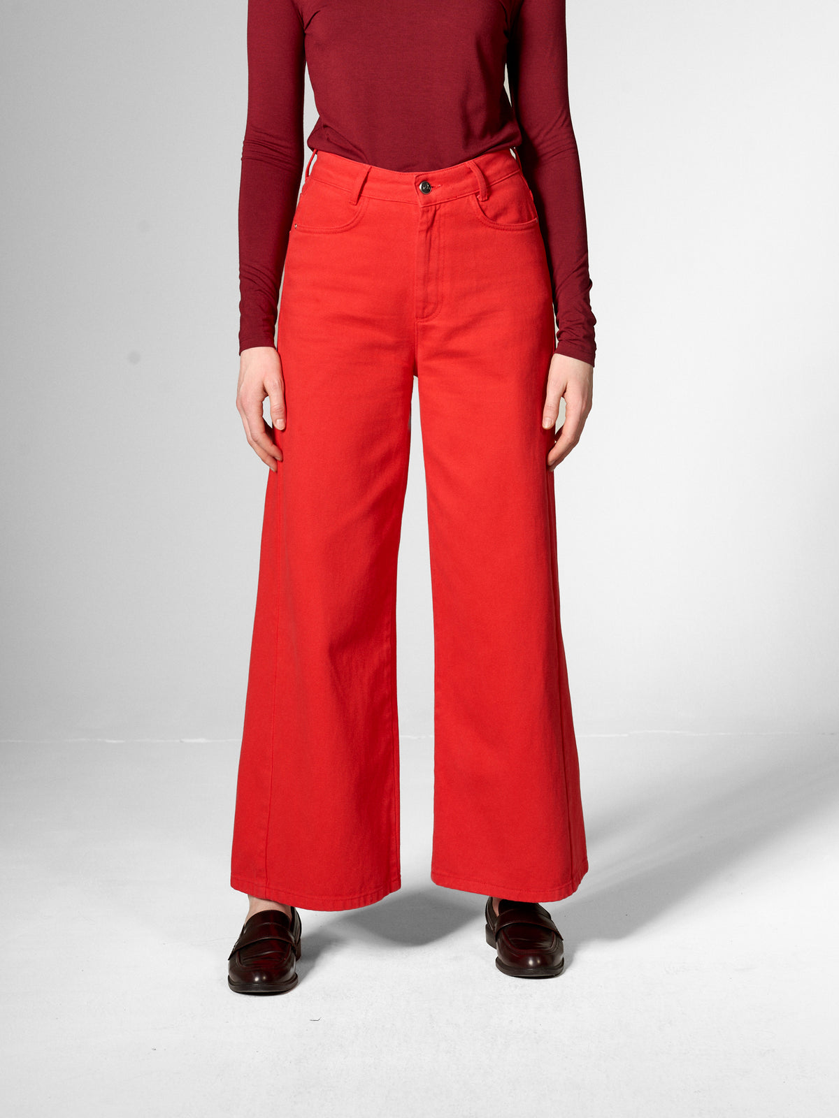 A woman wearing bright red wide leg trousers from Mademoiselle Yeye.