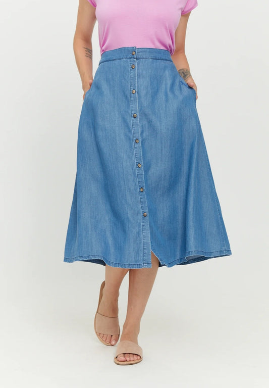 A-shape midi skirt in a mid denim wash, with a button placket down the front, an elasticated wIst and side pockets, made from sustainable Tencel™, by the German eco fashion brand Mazine.