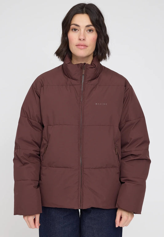 Woman wearing a chocolate brown puffer jacket with a visible brand logo on a white background