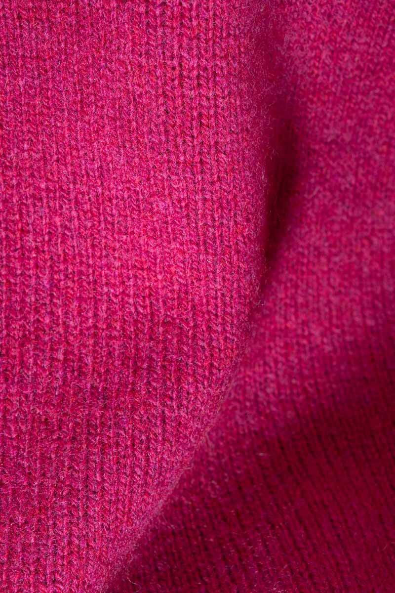 A close-up of a textured knit fabric in a rich magenta pink color, showing the detailed ribbed pattern and soft folds.