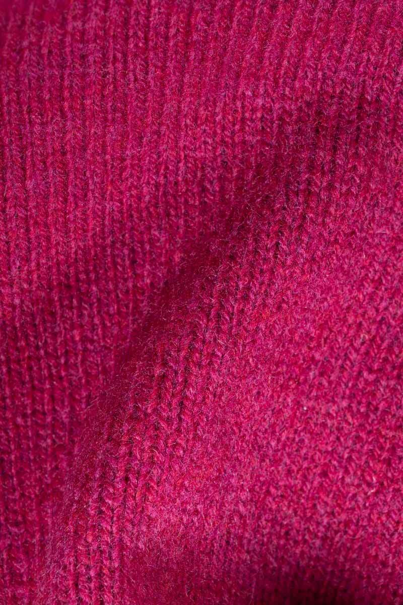 A close-up of a textured knit fabric in a rich magenta pink color, showing the ribbed pattern and soft yarn details.